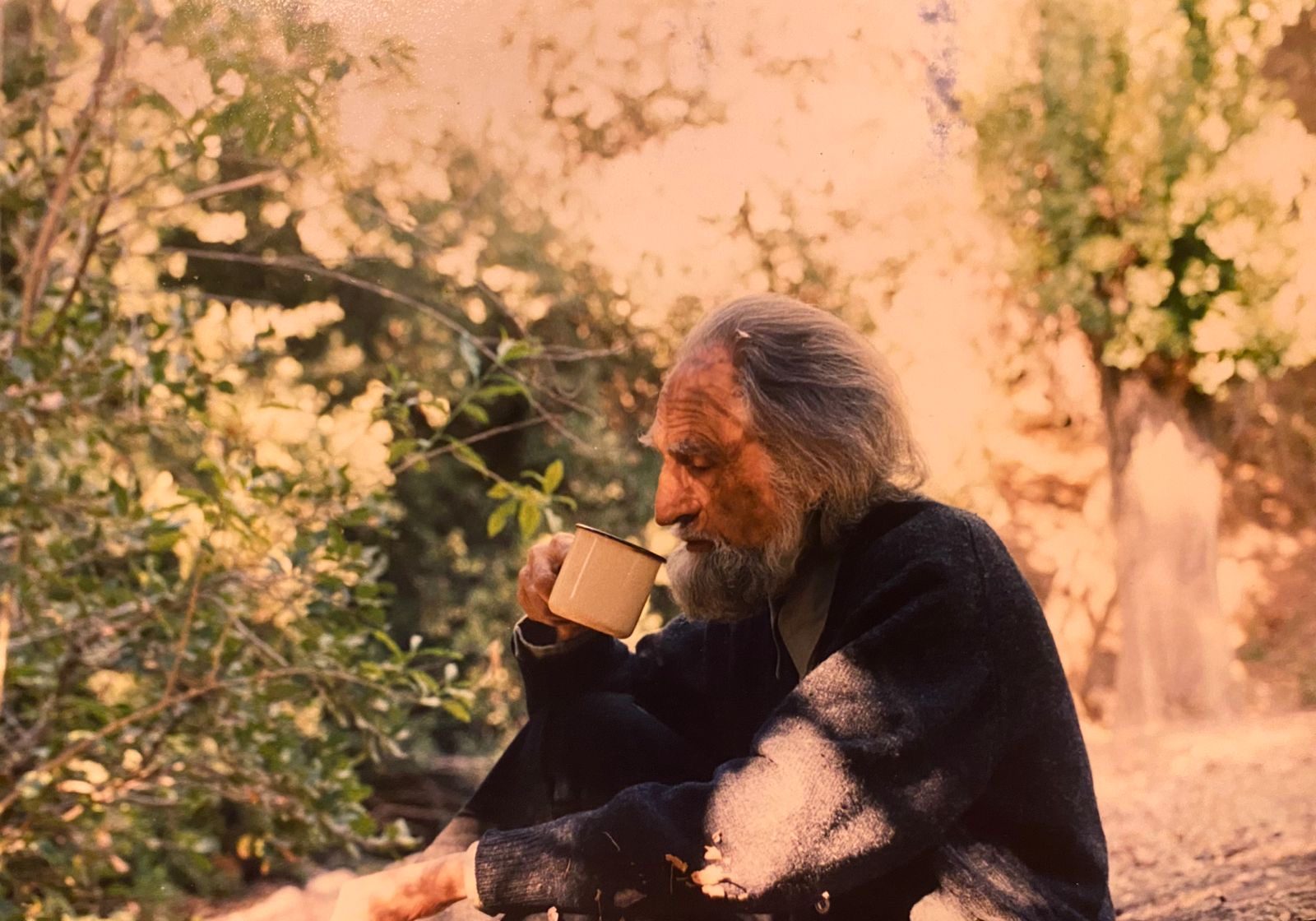 Gastón bebiendo de una taza en un jardín